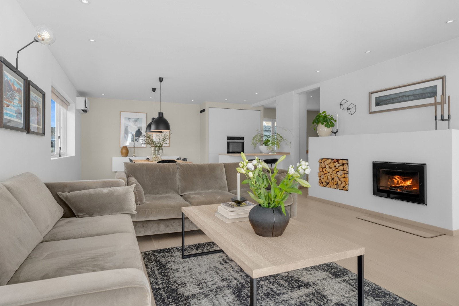 I senter av stuen er det en flott innebygd peis og integrert vedoppbevaring som skaper et moderne uttrykk. Galleribilde