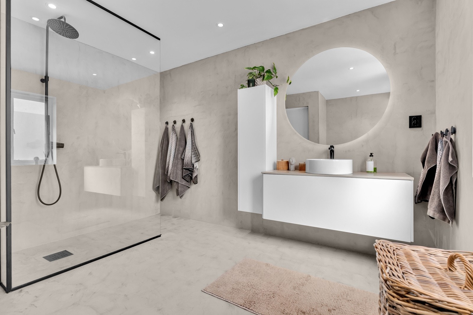 Badet er pusset opp i 2023 med mikrosement på gulv og vegger og innredning med sorte detaljer. Galleribilde