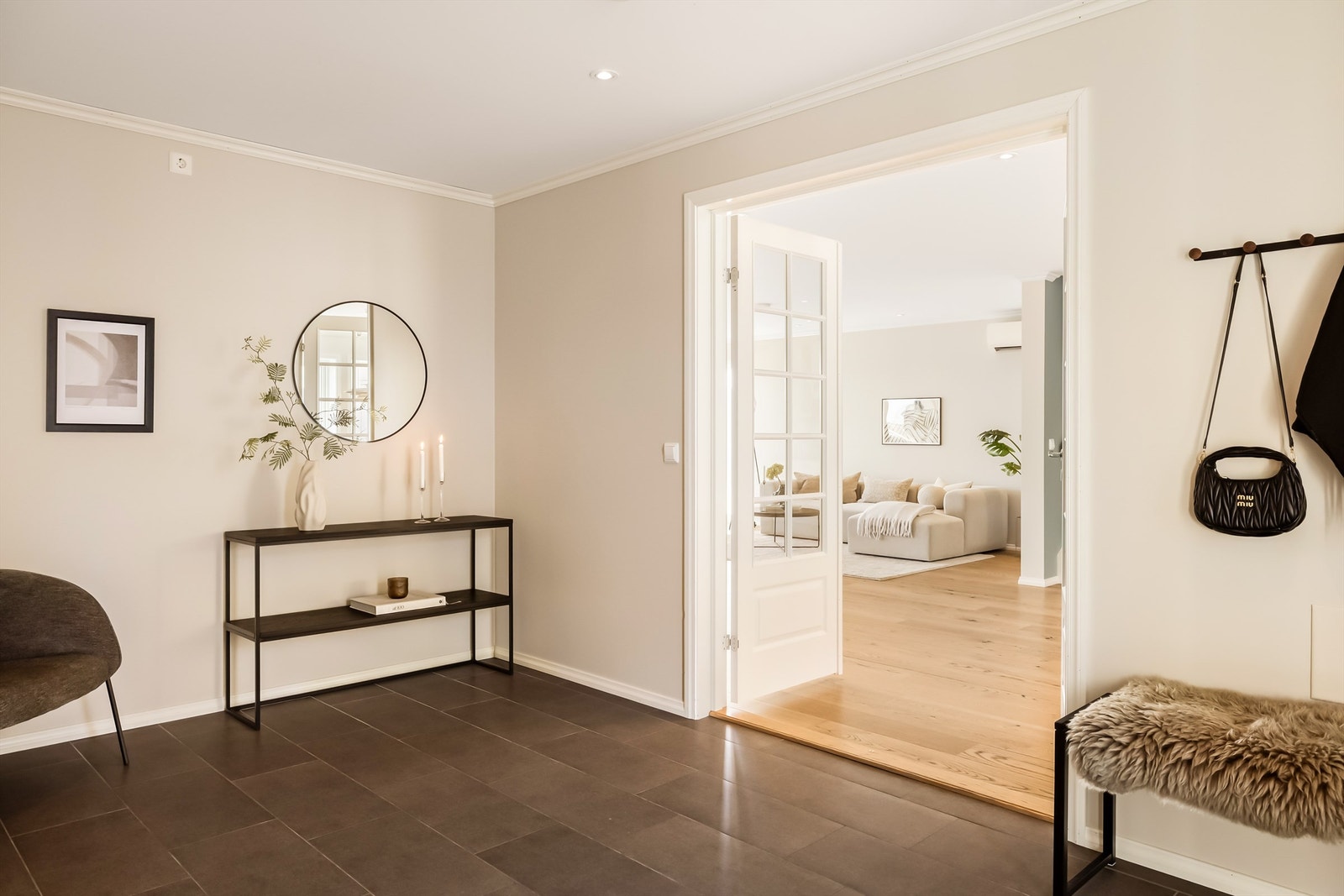 Fra den romslige gangen gir en tofløyet glassdør en elegant overgang til stuen og kjøkkenet. Galleribilde