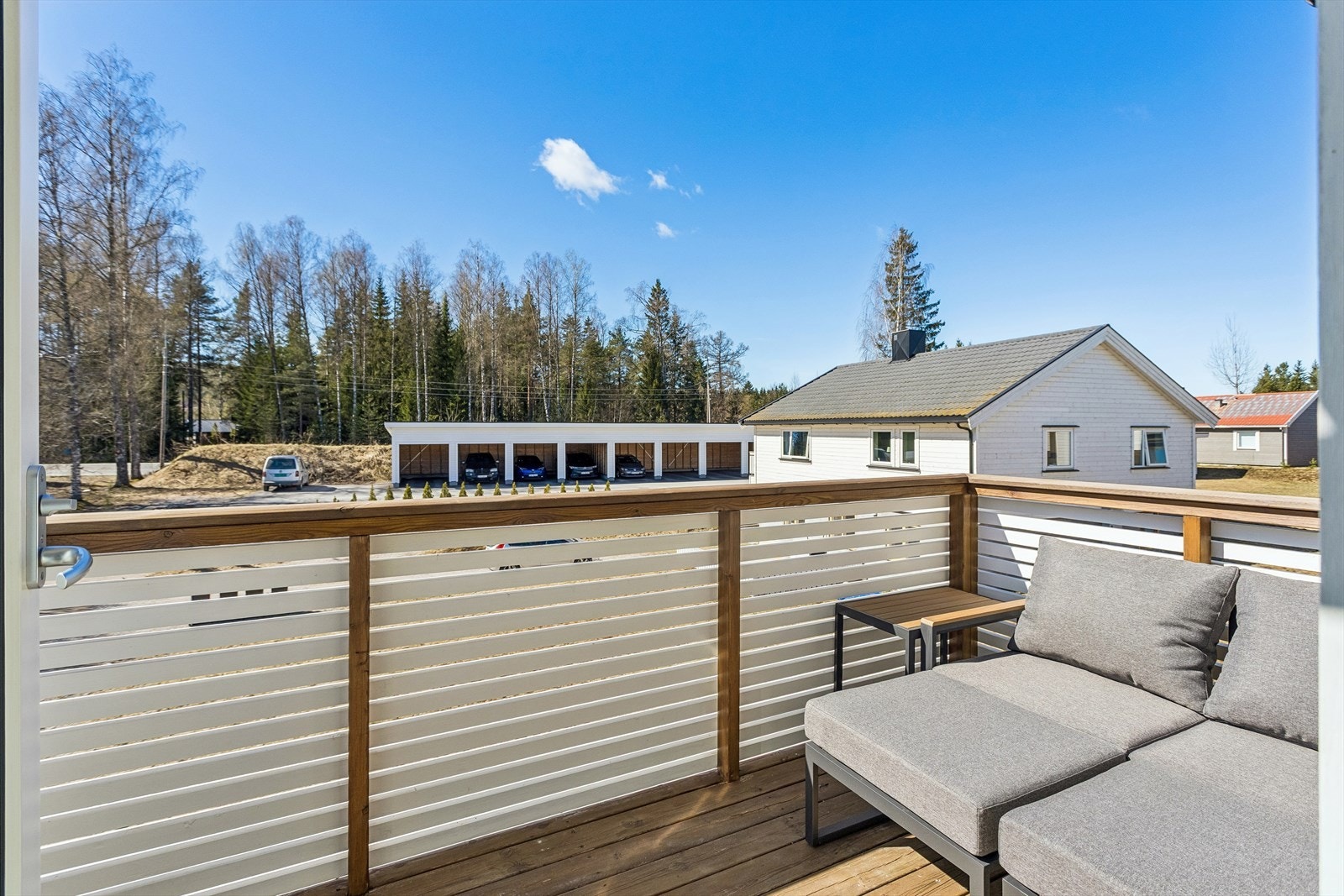 Utsikt fra balkongen mot fellesområdene og carportanlegget. Galleribilde