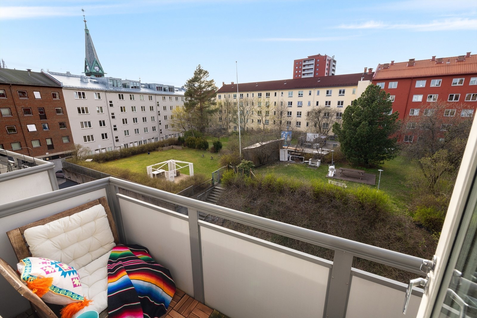 Balkongen vender mot åpent gårds- og byrom med utsyn mot omkringliggende bebyggelse Galleribilde