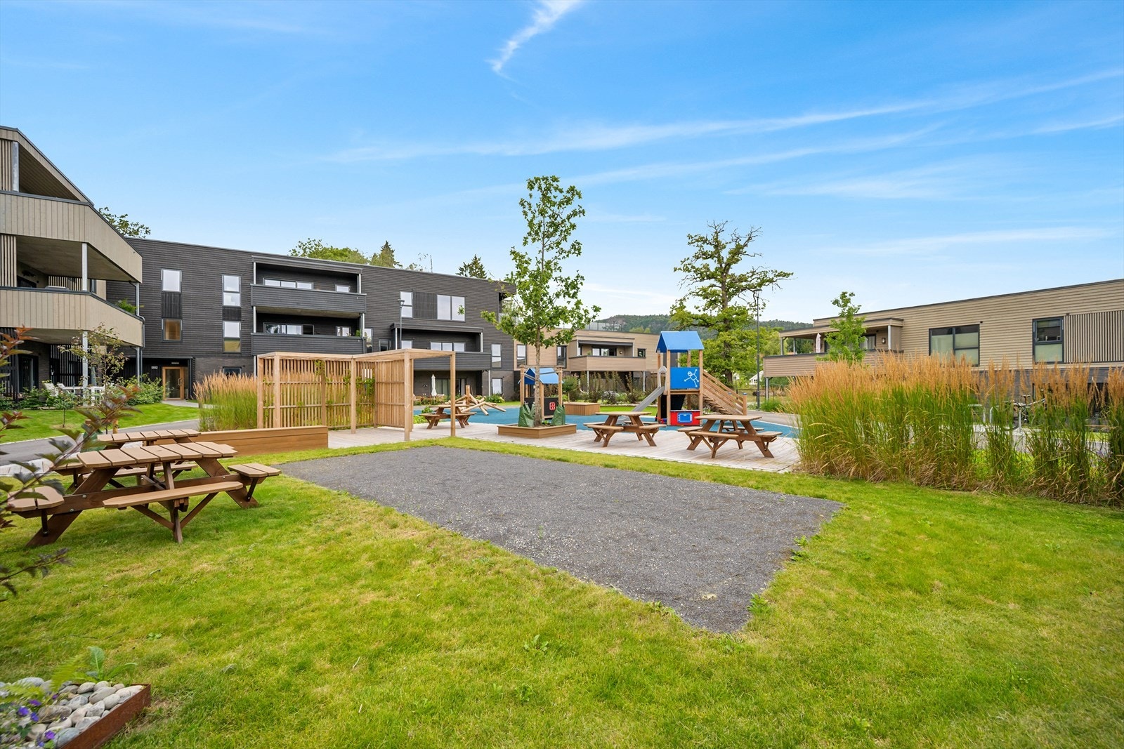 Beliggenheten er barnevennlig og etterspurt, med nærhet til lekeplasser, busstopp og idrettsanlegg, samt kort vei til sjø, barnehager, skoler og turområder. (sommerbilde) Galleribilde