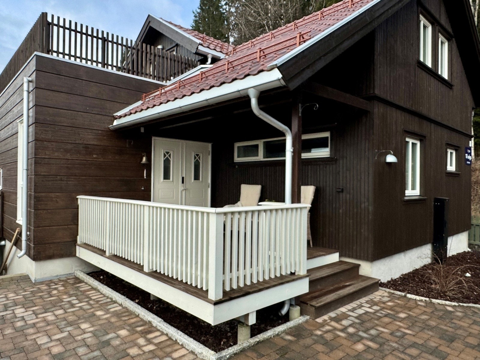 Stort overbygget inngangsparti som også er en av solterrassene | elegant dobbel inngangsdør Galleribilde