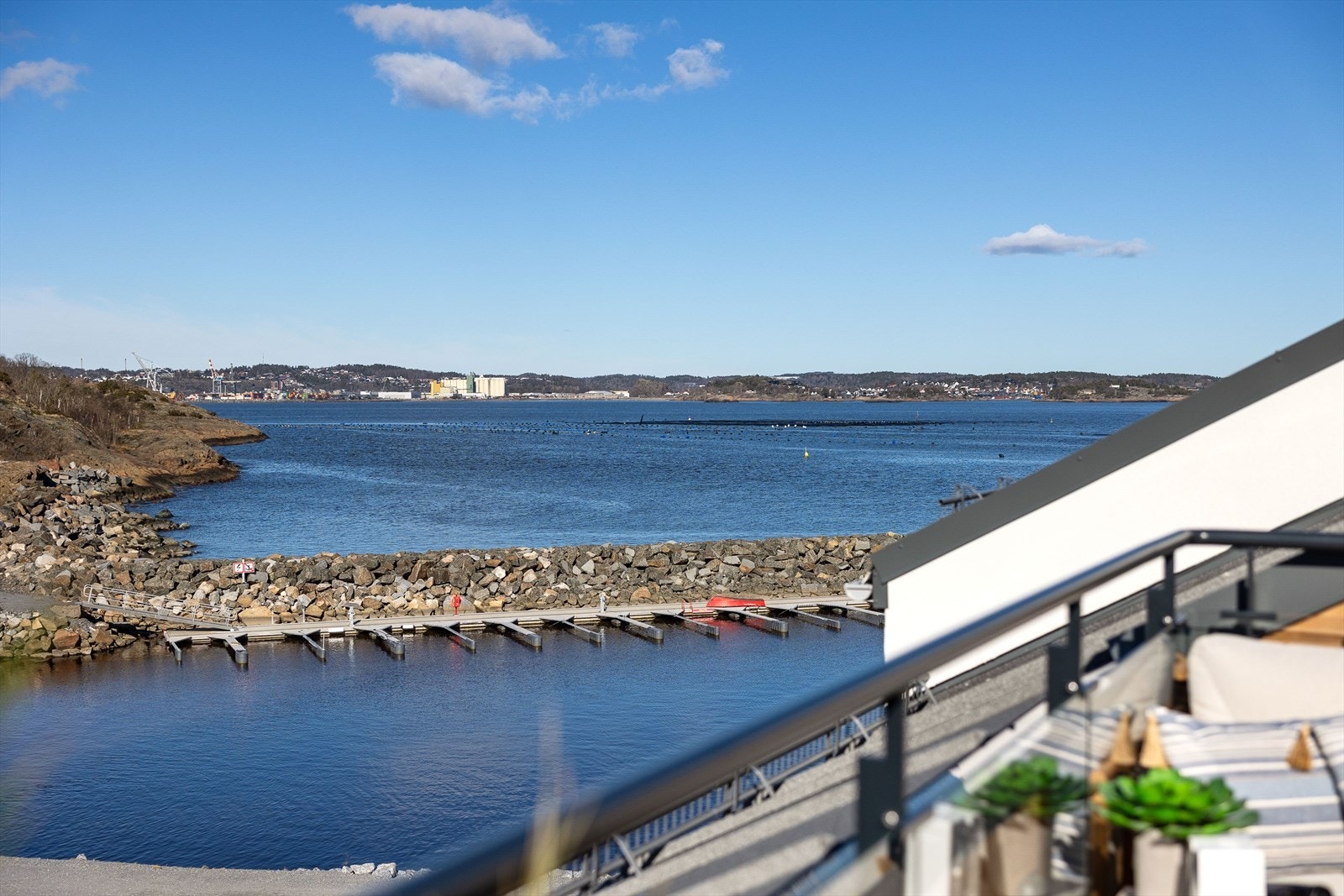 Fra balkongen har du også utsyn mot både kystlinjen og båthavna - en perfekt plass for rolige morgener, sosiale kvelder eller bare et øyeblikk for deg selv i maritime omgivelser. Galleribilde