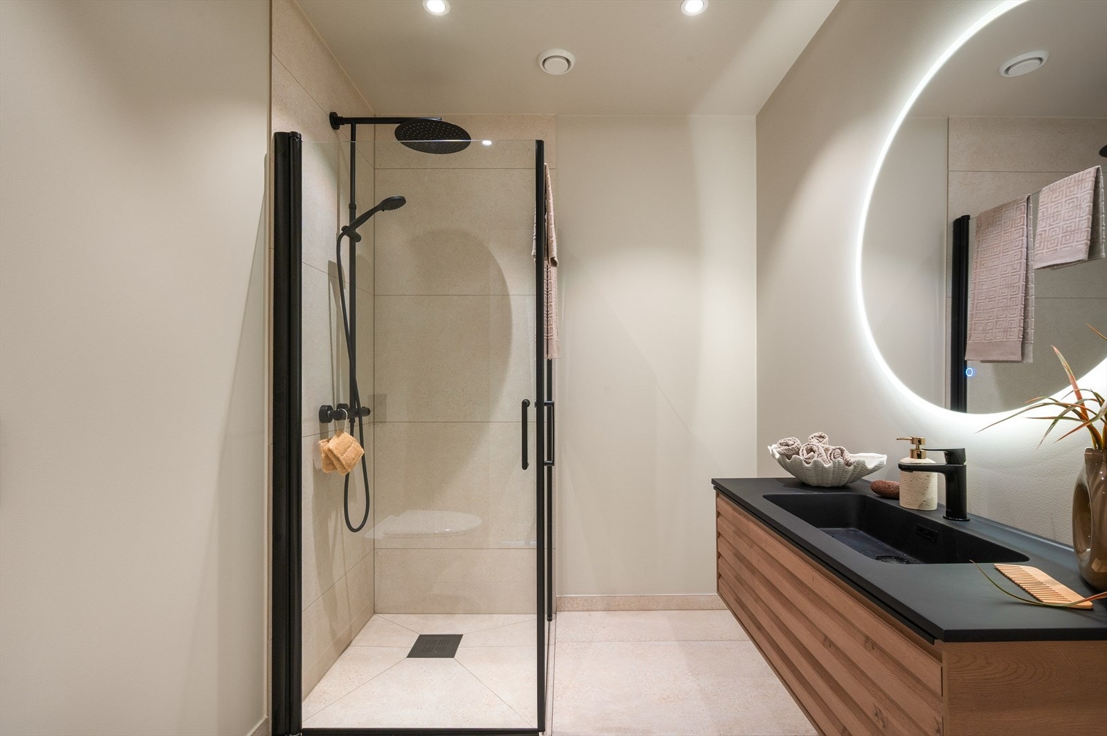 - Badet er innredet med speil m/ belysning, vegghengt toalett, dusj og benkeskap m/ servant - Galleribilde