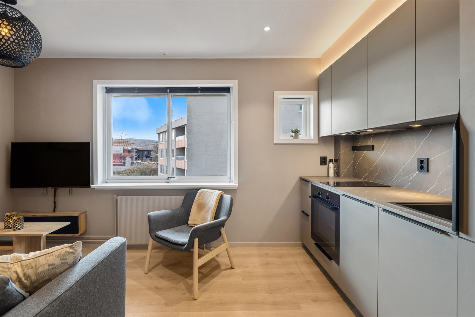 Gjennomtenkte materialvalg med laminat benkeplate og slette, moderne fronter. Parkettgulv binder sonene sammen. Galleribilde