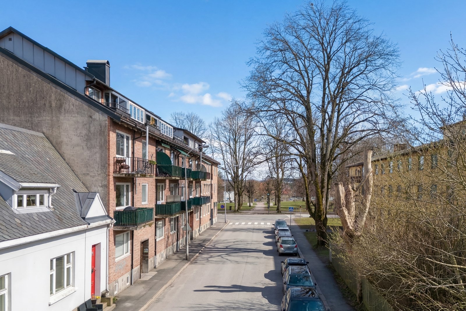 Den teglsteinskledde bygården fra 1954 gir et pent, urbant inntrykk i møte med de ryddige gatene og nabolagets grøntområder. Galleribilde