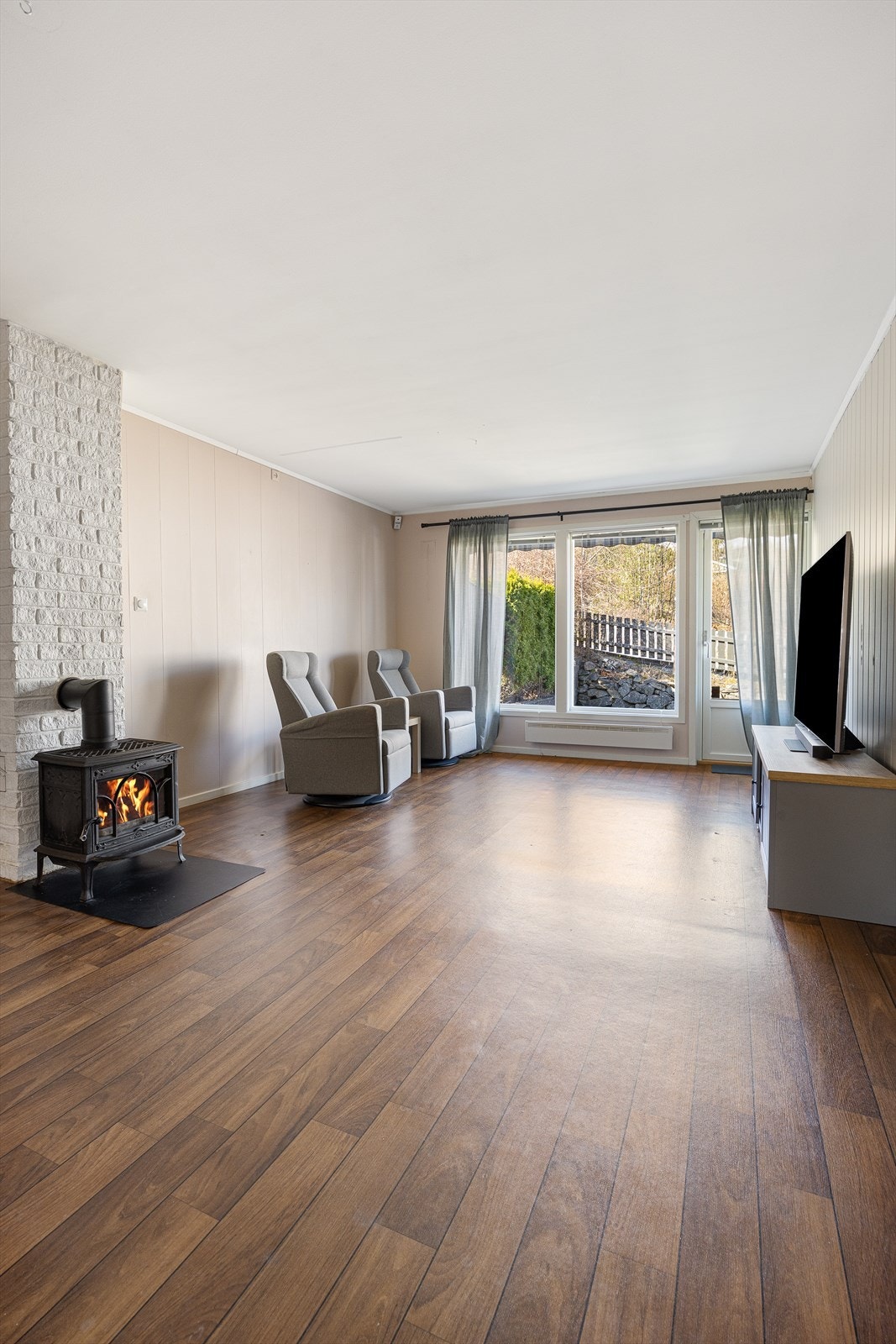 Fra stuen er det direkte utgang til en steinplatting på 8 m² og den private hagen. Galleribilde