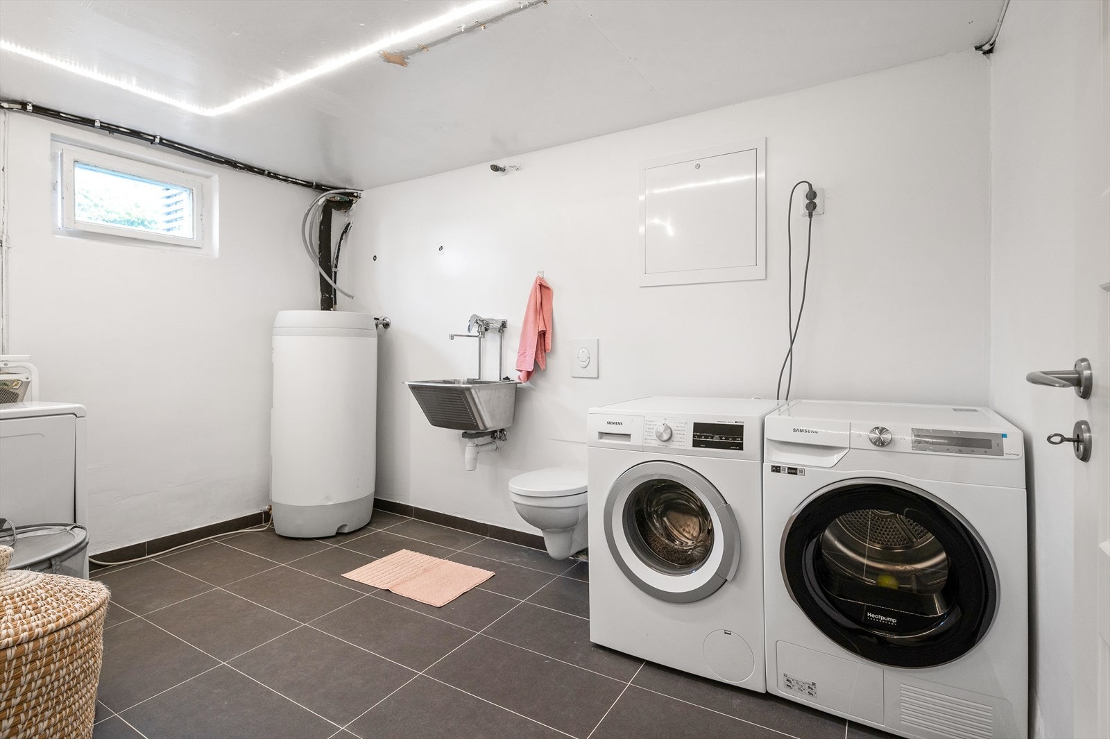 Vaskerommet ble pusset opp i 2021 og har flislagt gulv, opplegg for vaskemaskin, praktisk skyllekum og 200-liters varmtvannsbereder. Galleribilde