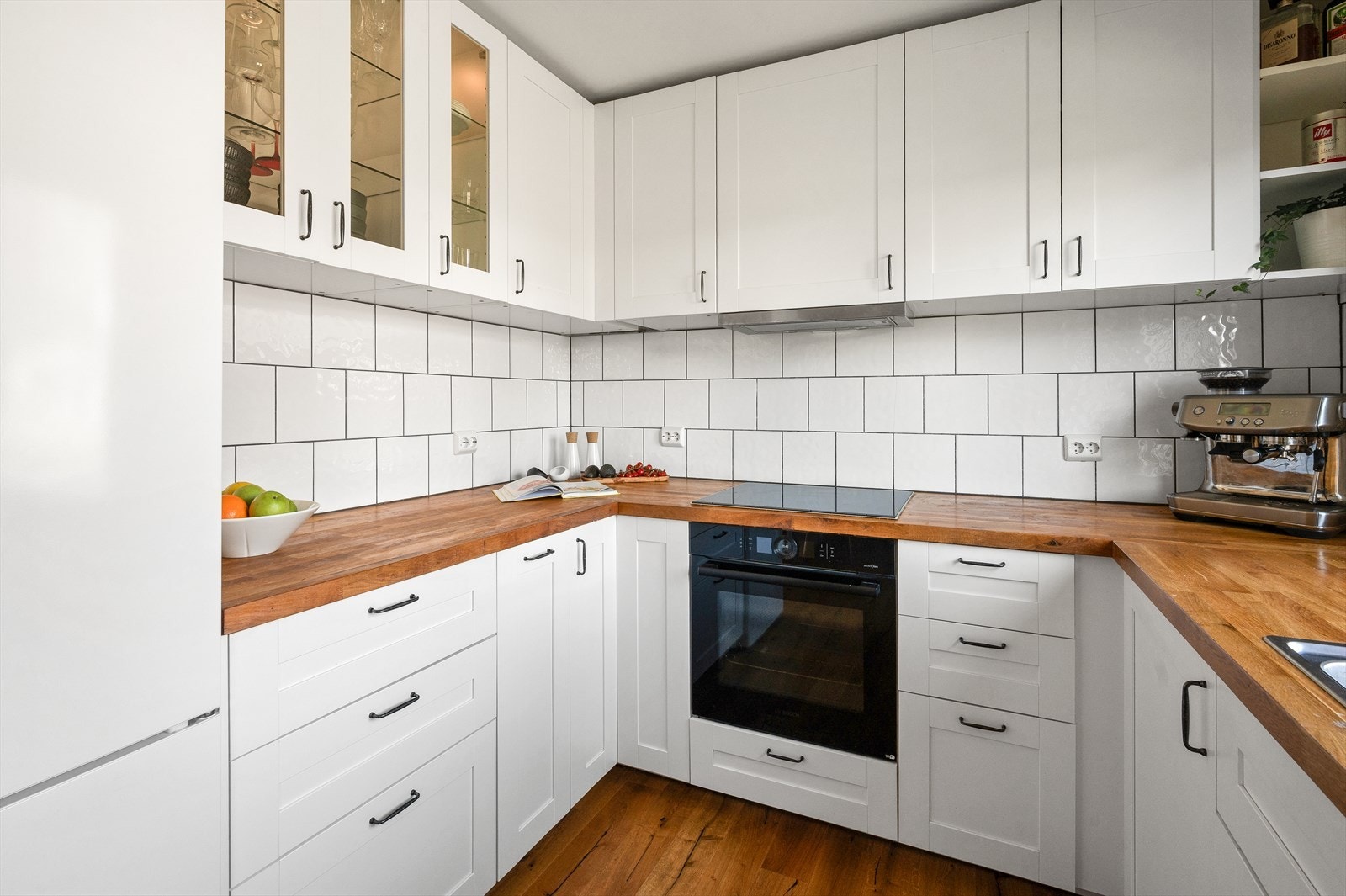 Innredningen har profilerte fronter i lys utførelse. Enkelte overskap har innslag av glassdører, som bidrar til et lett og elegant uttrykk. Galleribilde