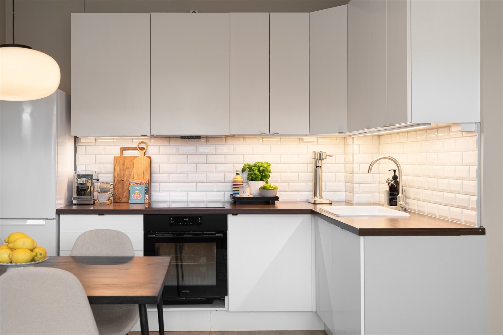 Kjøkkeninnredning fra IKEA fra 2014 med under-/overskap og slette fronter. Integrerte hvitevarer er komfyr, platetopp og oppvaskmaskin, samt frittstående kjøleskap (alle hvitevarer kjøkken medfølger). Galleribilde