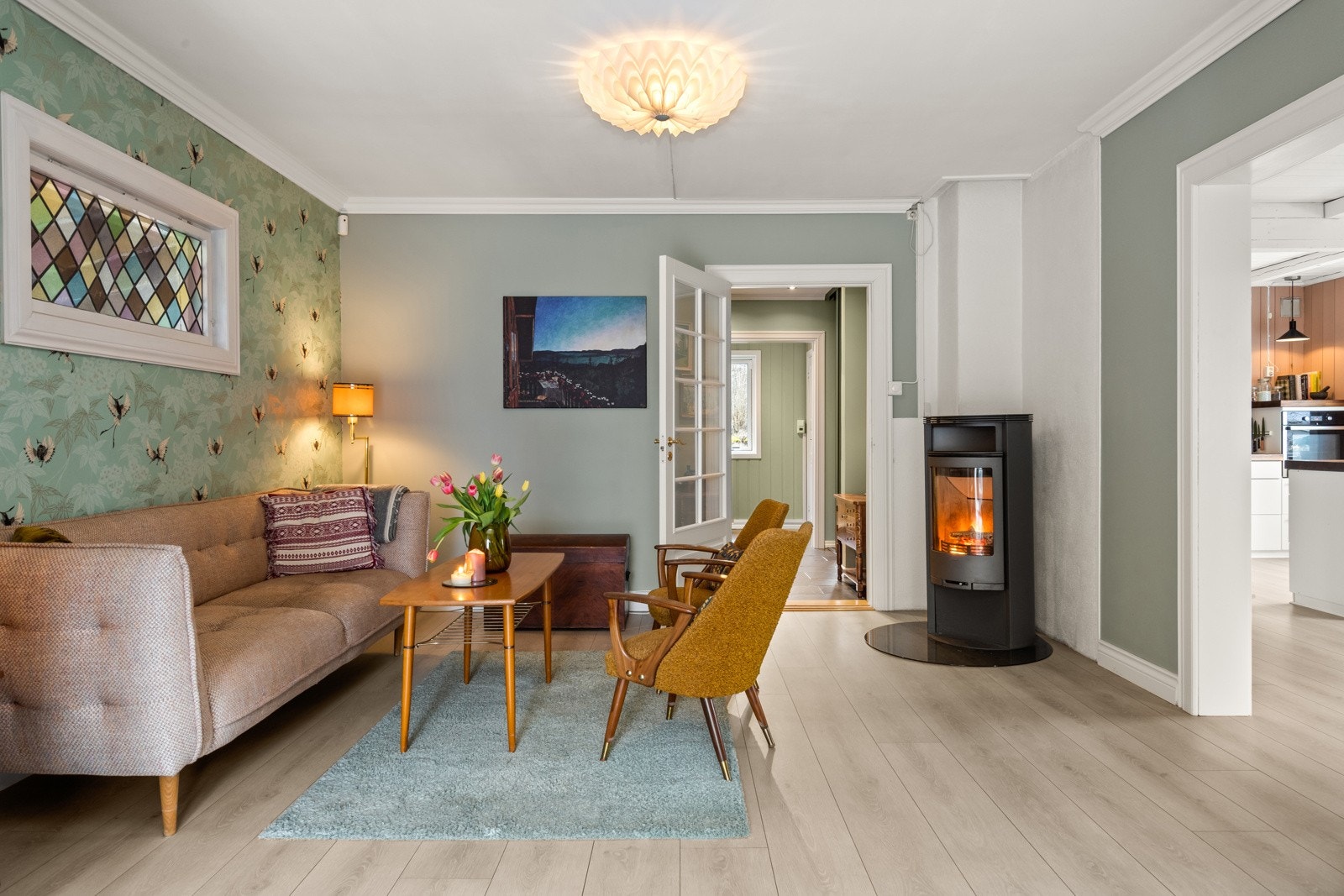 Stue med lun atmosfære og moderne vedovn som skaper ekstra hygge på kjølige dager. Lyse overflater og god planløsning gir en romslig følelse. Galleribilde