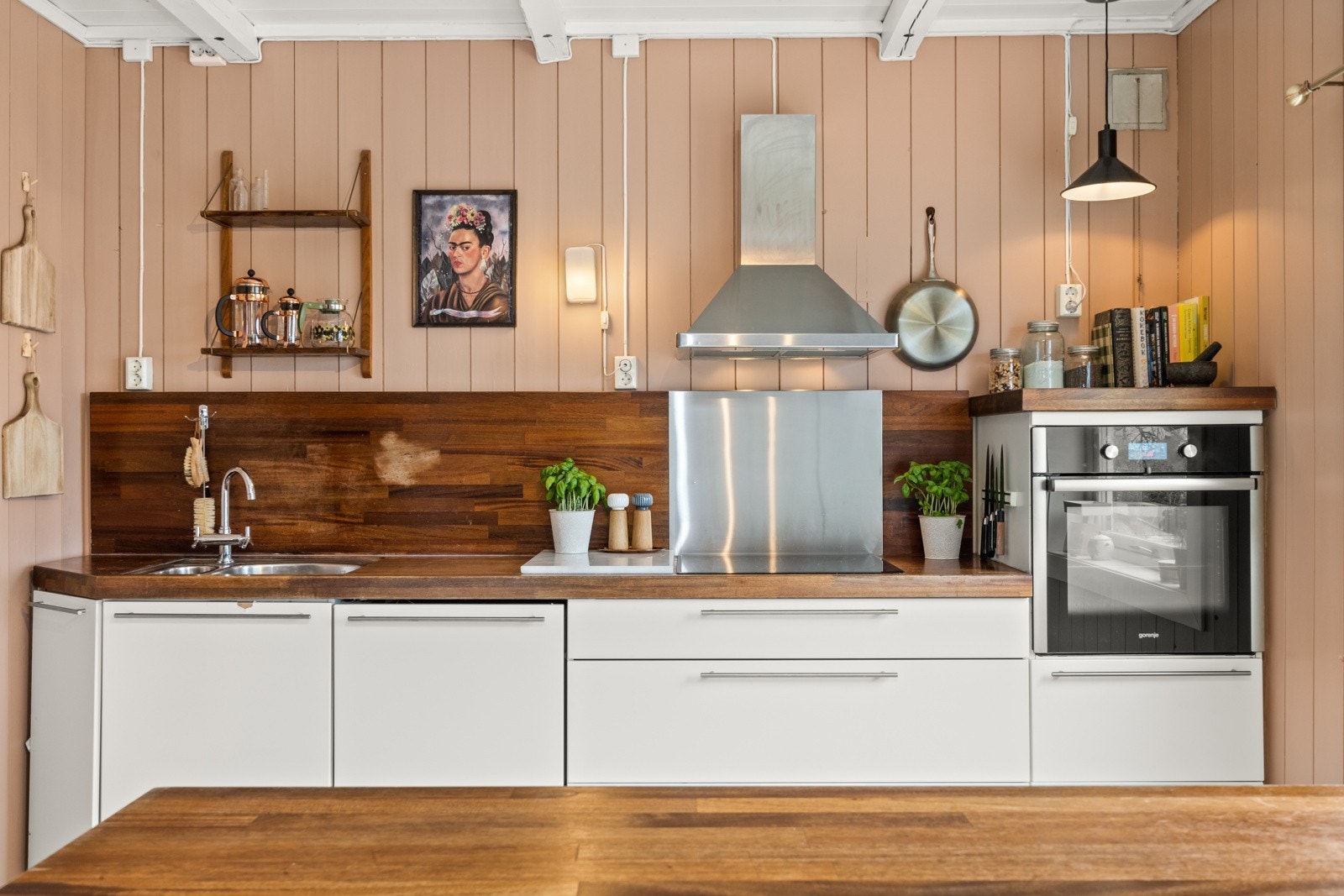 Kjøkken med gode arbeidsflater, moderne hvite fronter og benkeplate i tre som gir et varmt uttrykk. Galleribilde