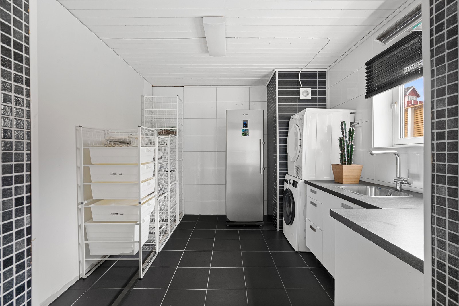 Vaskerom i kjeller med god plass. Her er det også en plastisk innredning med godt med benkeplass samt en dyp vask. Galleribilde
