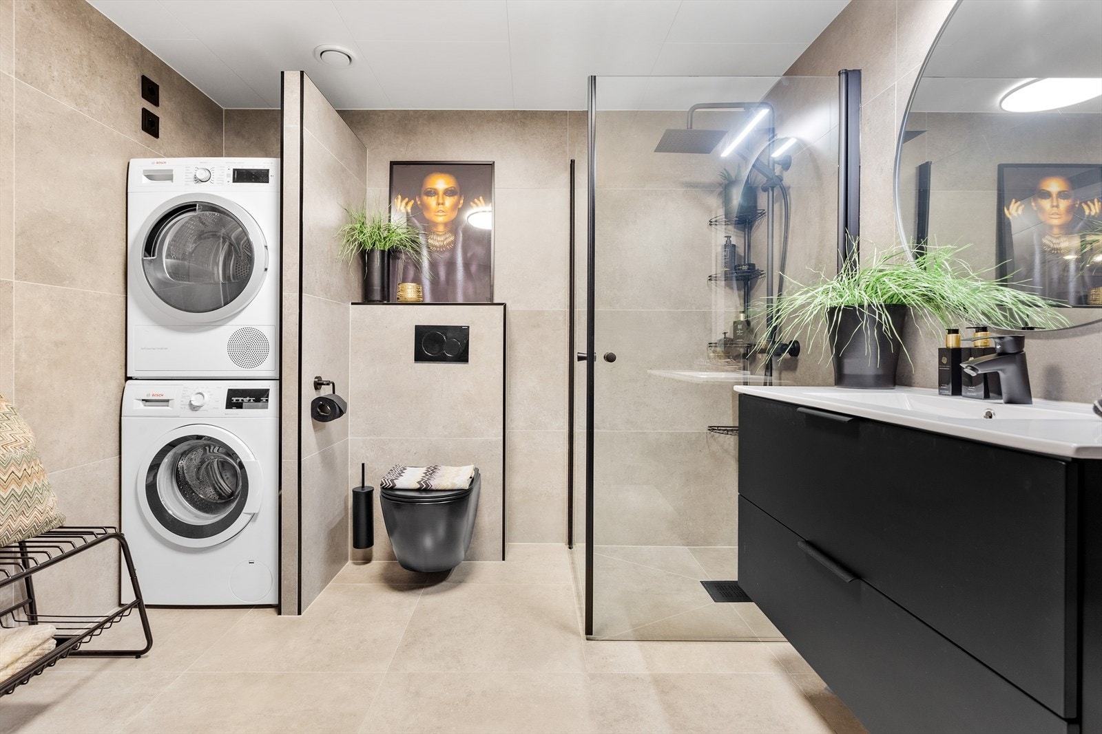 Badet er helfliset med moderne, grå fliser på både gulv og vegger, noe som gir et helhetlig og stilrent inntrykk. Galleribilde