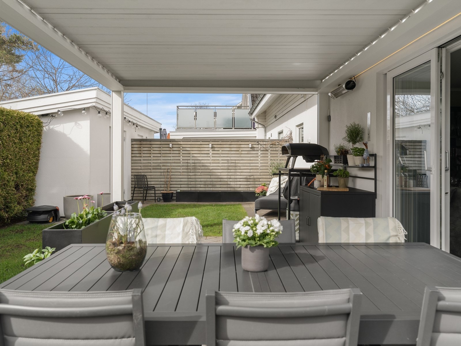 Skjermet og lun uteplass med pergola, elektrisk styrte screens, integrert belysning og varme - helt uten innsyn. Galleribilde
