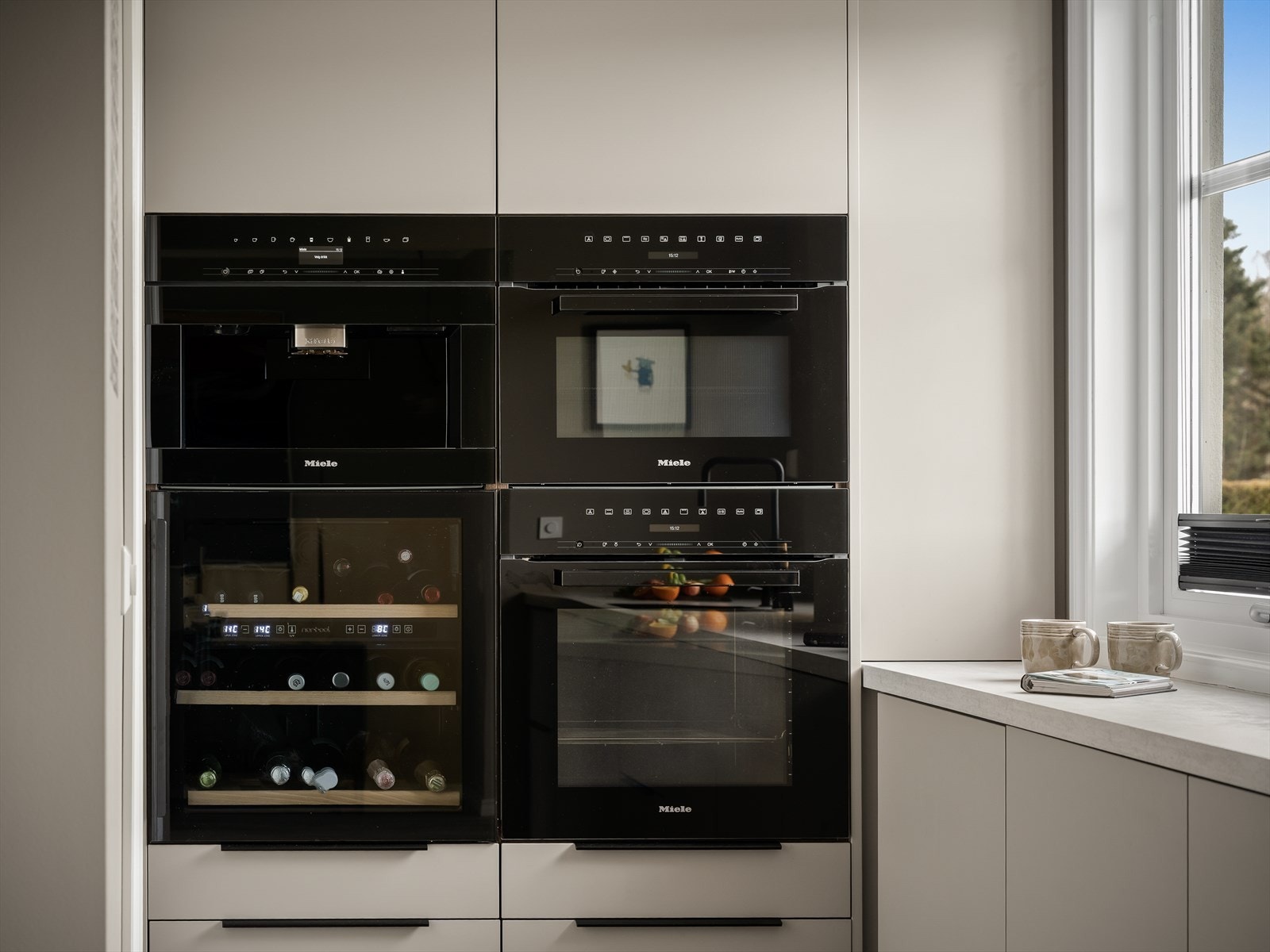 Lekkert kjøkken med integrert vinskap fra Norcool samt kaffe-/temaskin, dampovn og kombinert mikro-/stekeovn fra Miele - en komplett og gjennomført løsning i høy kvalitet. Galleribilde