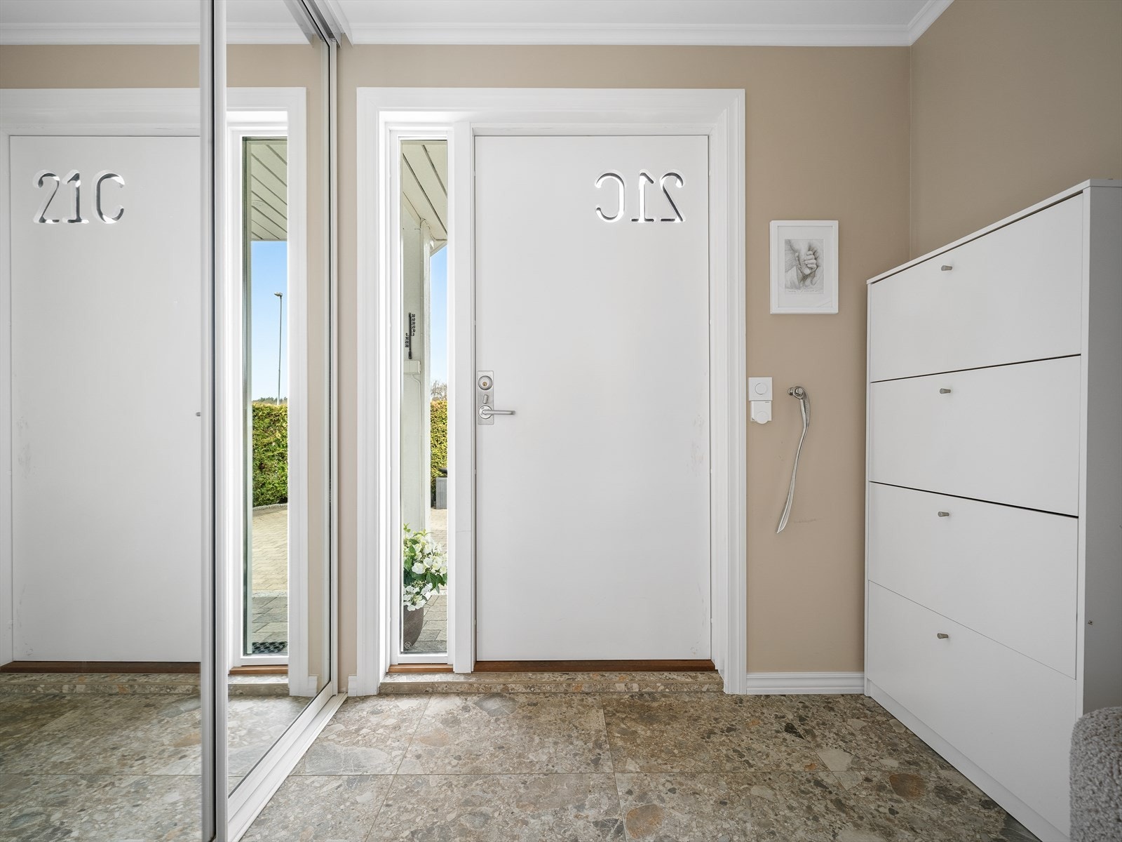 Stilig inngang med skyvedørsgarderobe og delikate gulvfliser Galleribilde