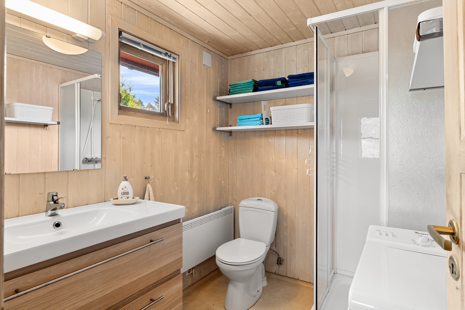 Badet er funksjonelt utformet med dusj, toalett og opplegg for vaskemaskin, noe som er praktisk for både korte og lengre opphold på hytten. Galleribilde