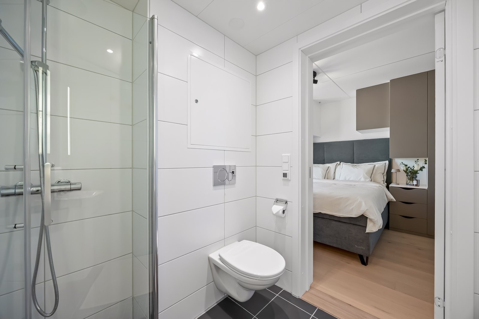 Badet har innredning med nedfelt servant, veggmontert toalett og dusjvegger/hjørne. Galleribilde
