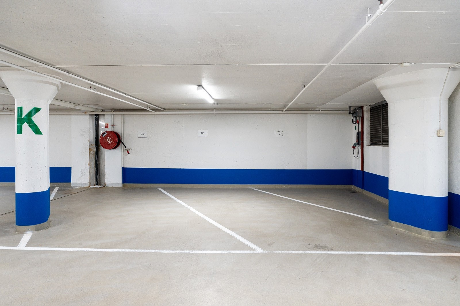 Plass 167 til høyre, med et lite ekstra hjørne brukt av denne plassen. K2 innerst bak lukket purt. Innfrastruktur for el-bil lader betalt av tidligere eier. Galleribilde