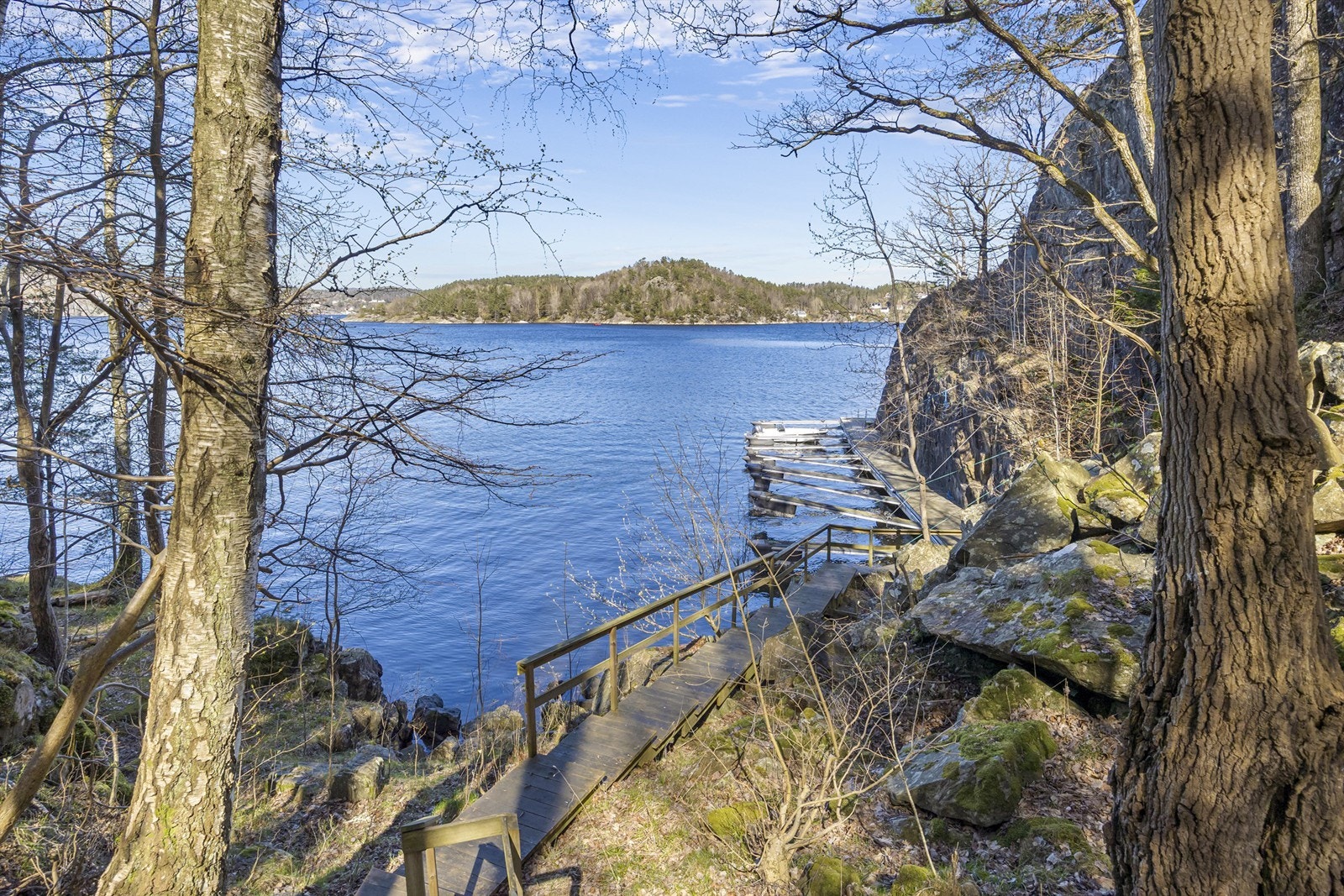 En sti med trapper i tre leder ned til bryggeanlegget og båtplassen. Badestige er det også. Galleribilde