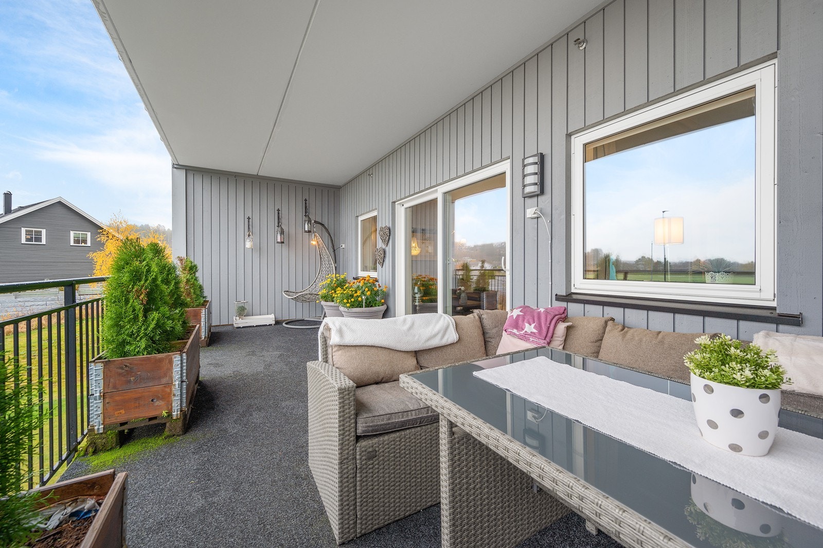 Fra stuen er det utgang til en romslig og overbygd veranda. Her får du en lun og skjermet uteplass med kveldssol og fritt, landlig utsyn - perfekt for avslapning etter jobb eller hyggelige måltider utendørs. Galleribilde