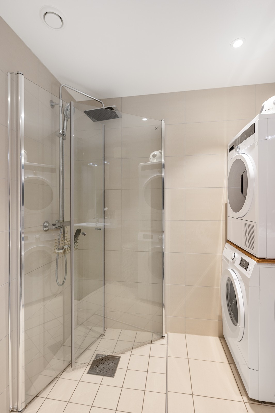 Videre inneholder badet toalett, opplegg for vaskemaskin og dusjsone med innfellbare glassdører. Galleribilde