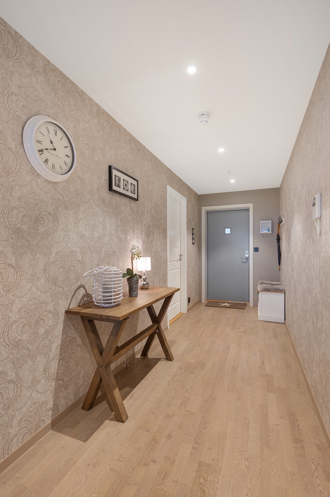 Entréen er romslig og praktisk utformet, med tapetserte vegger, 3-stavs eikeparkett på gulv og downlights i himling. Galleribilde