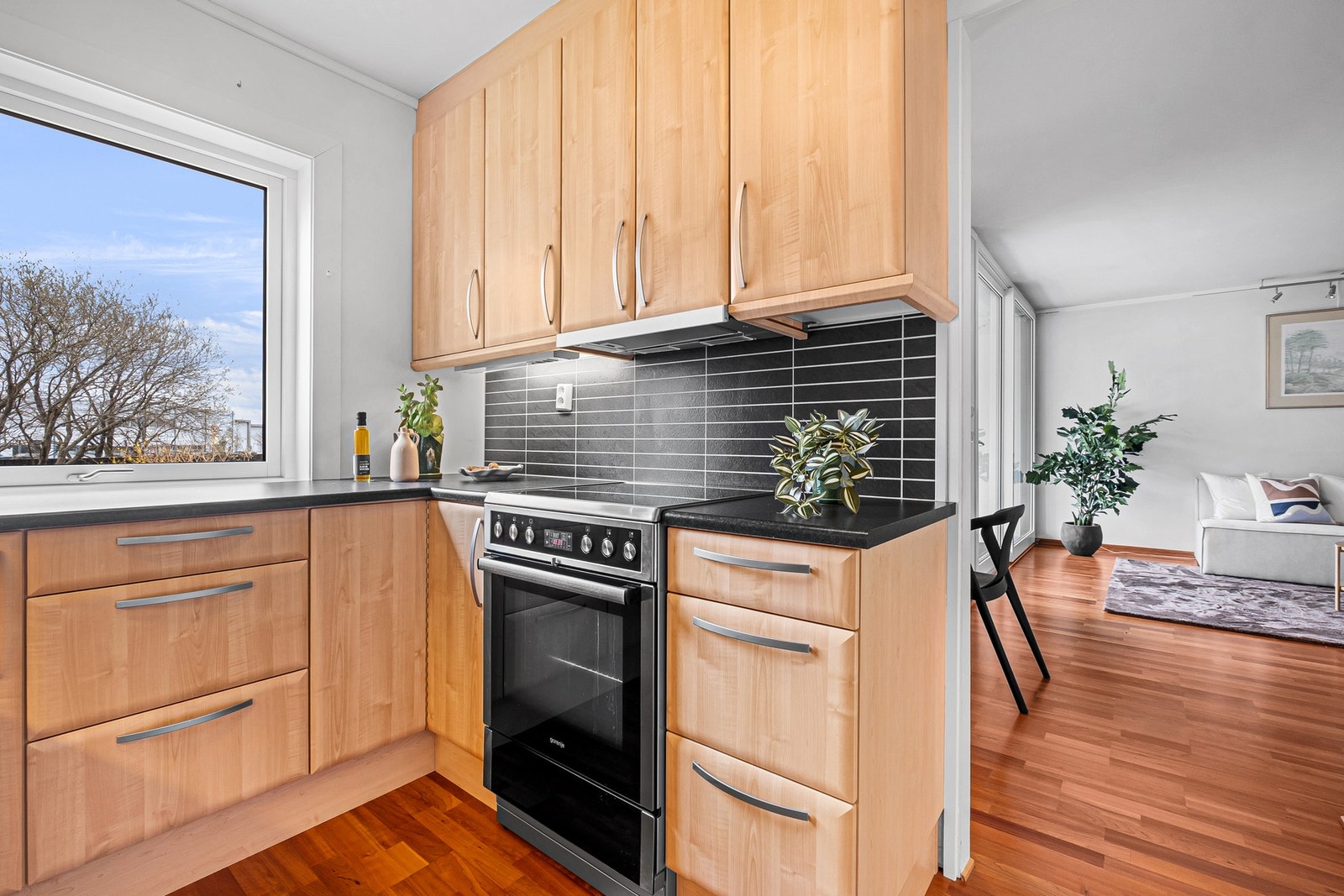 Mørkt backsplash som passer inn med innredningen, samt belysning under overskapene Galleribilde