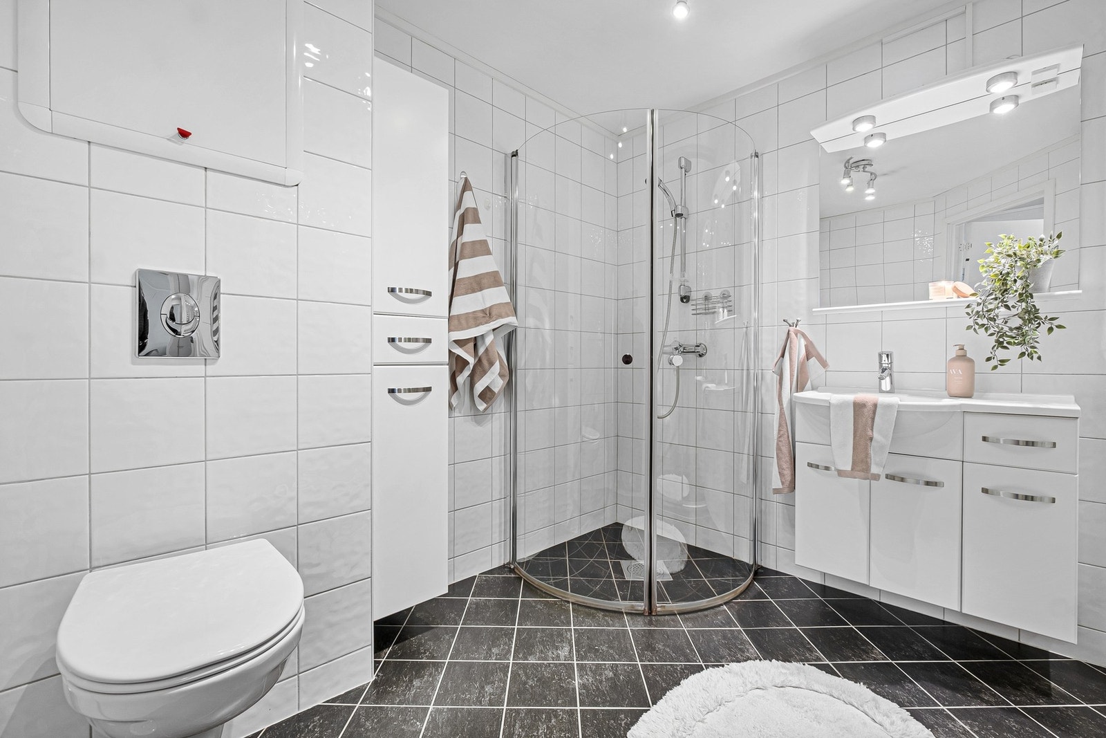 Badet er flislagt med et stilrent og tidløst preg Galleribilde