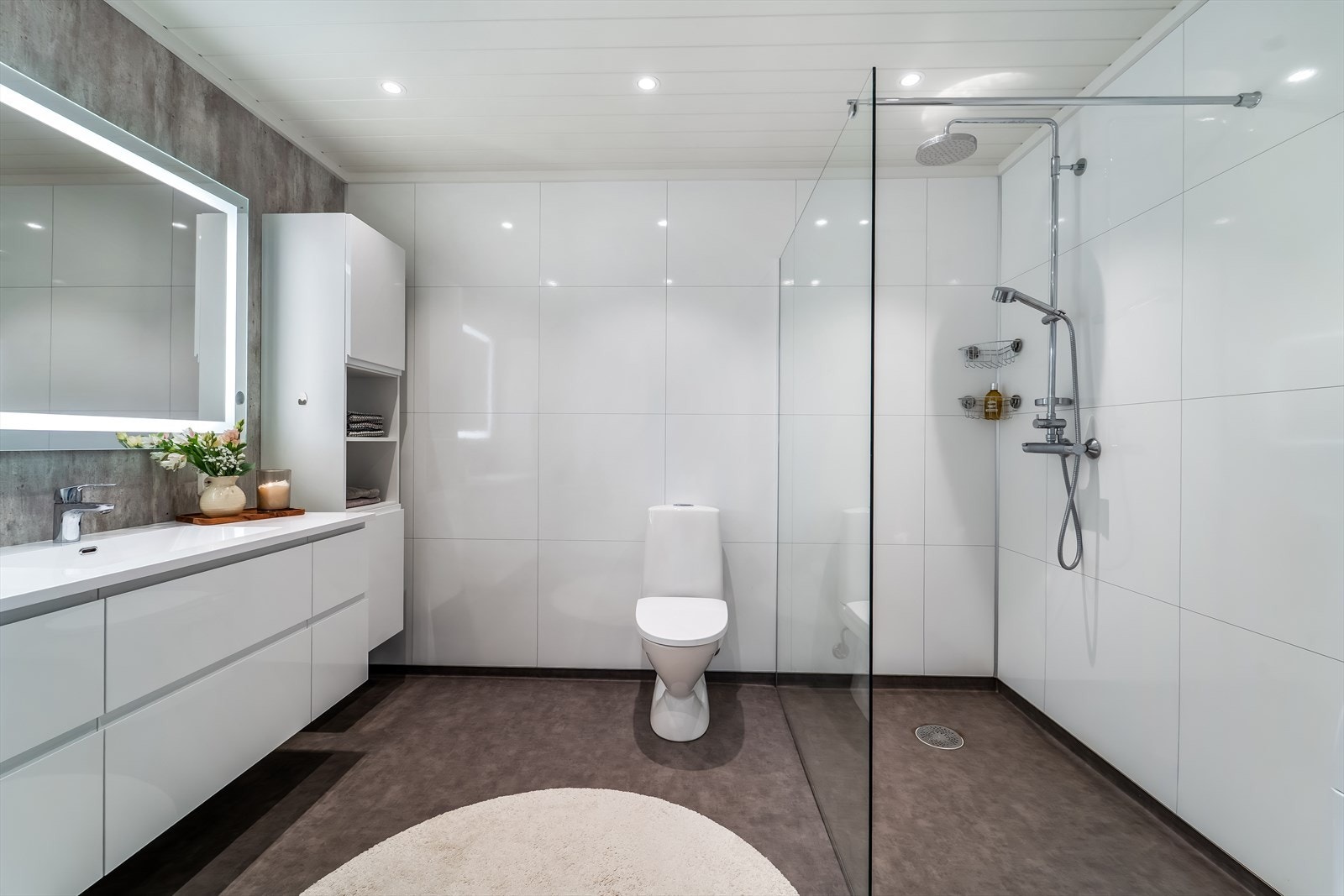 Tidsriktig innredet bad med belegg på gulv med varmekabler og baderomsplater på vegg. Galleribilde
