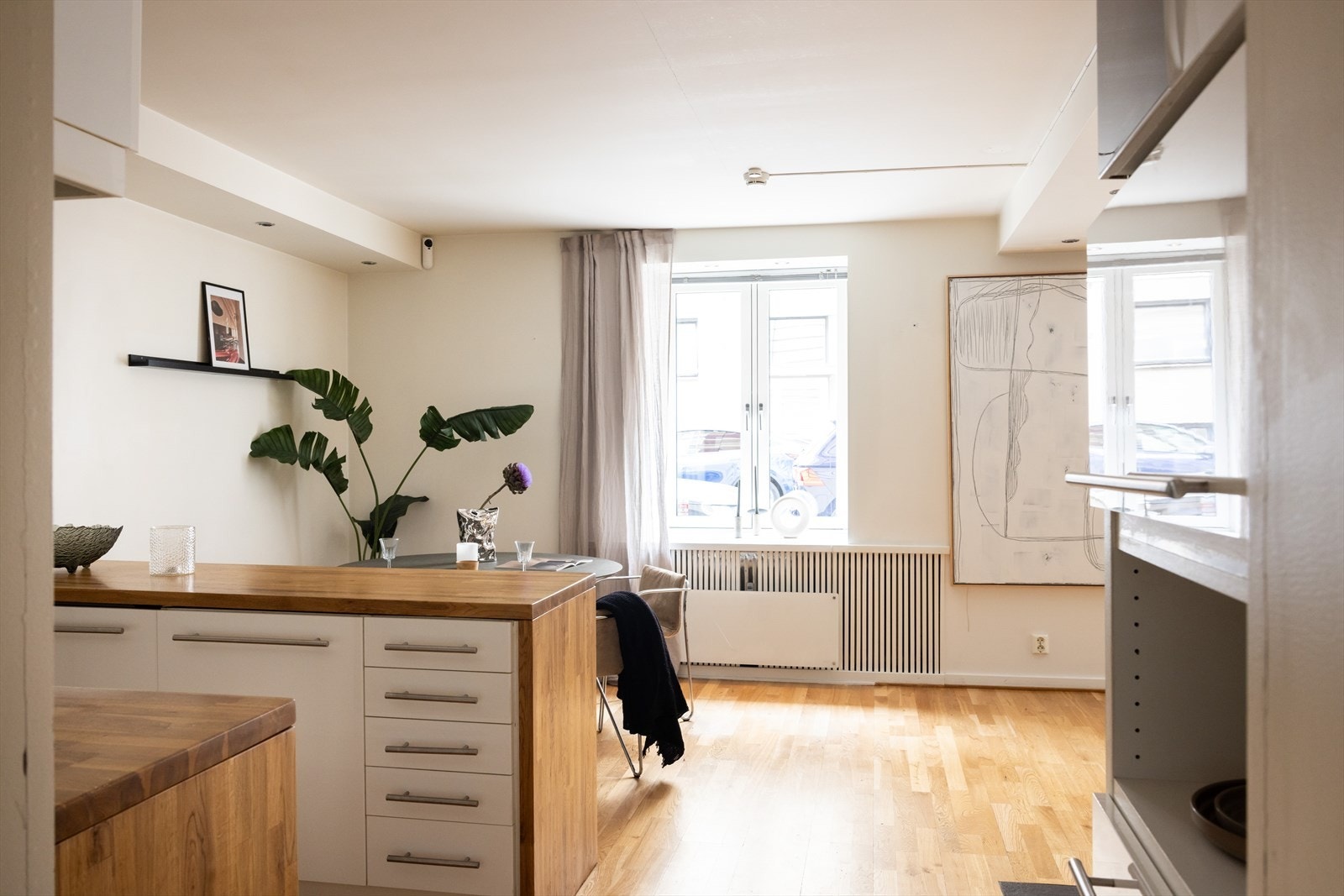 Lyst og hyggelig kjøkken med praktisk kjøkkenøy mot spiseplassen. Galleribilde