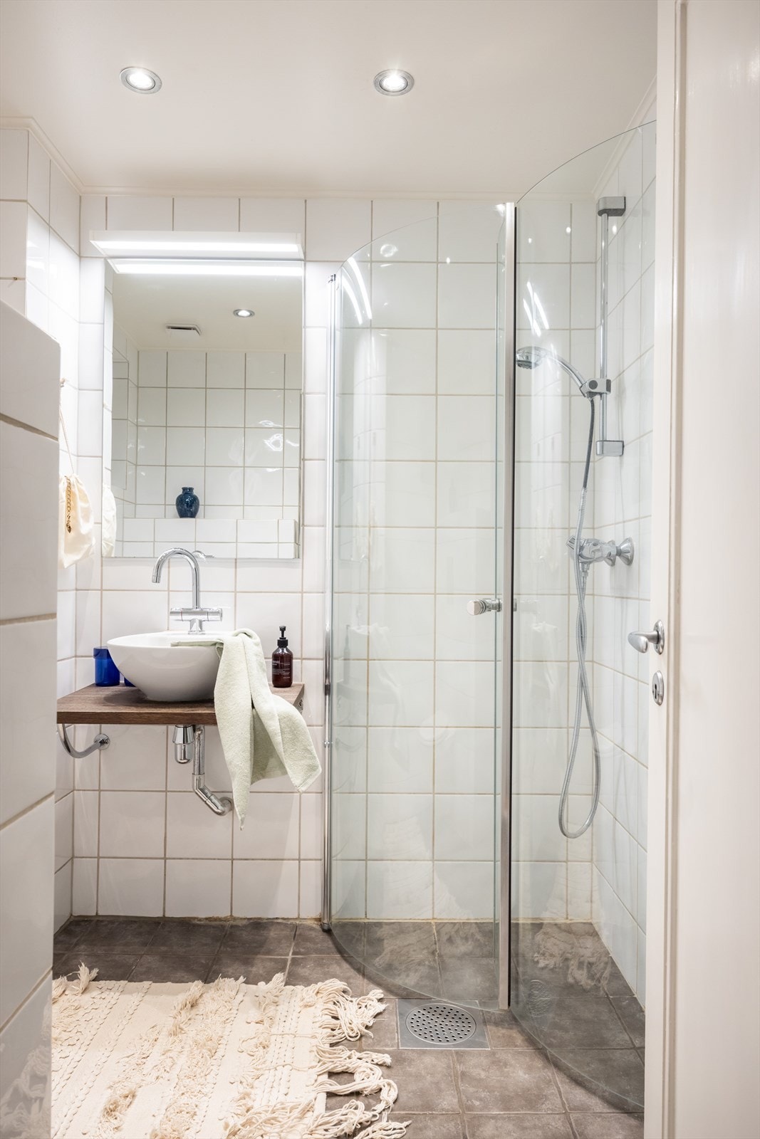 Badet inneholder dusjhjørne, servant og vegghengt toalett. Galleribilde