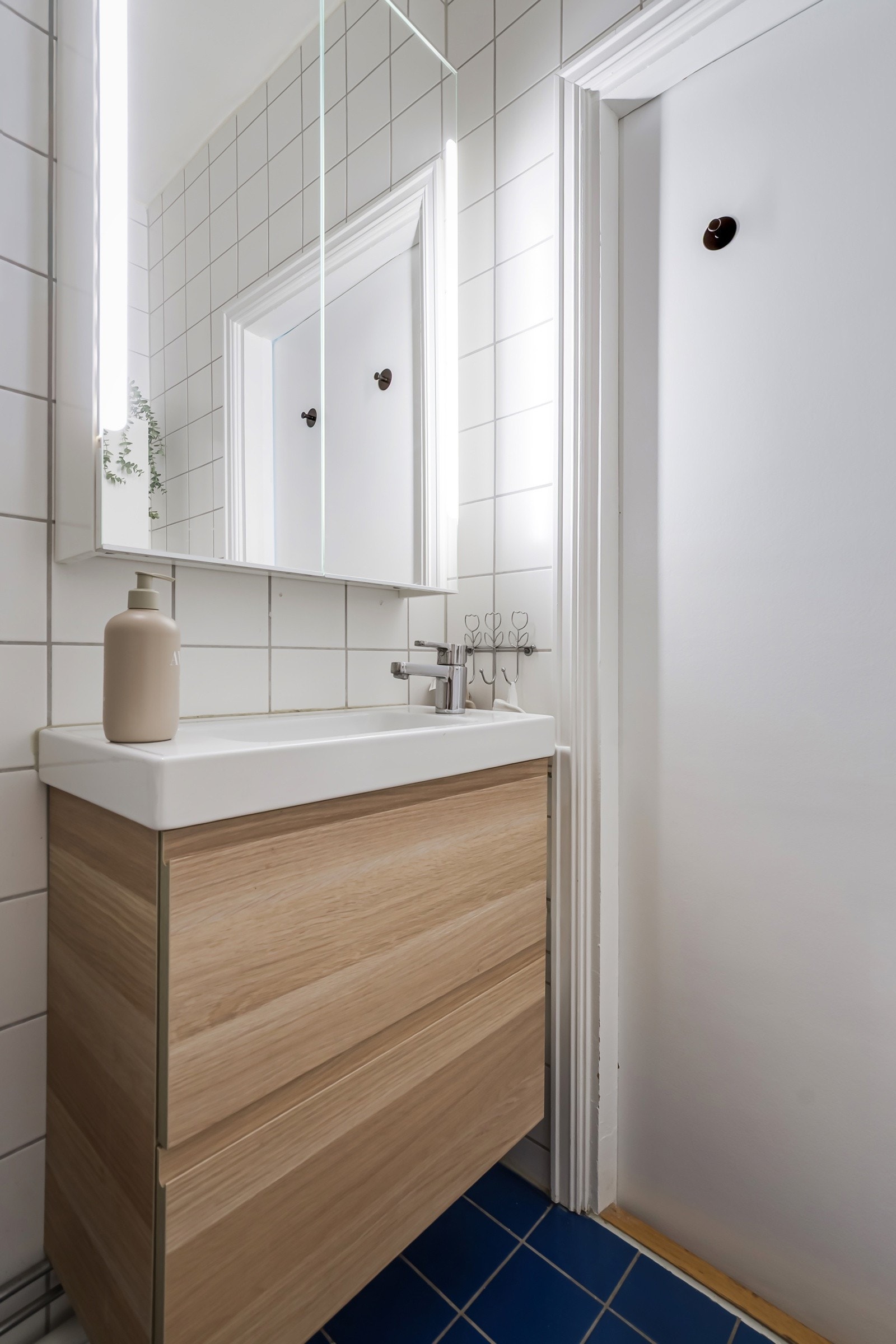 Badet har vegghengt servantskap med skuffer, speilskap med belysning, dusjhjørne, gulvstående toalett og opplegg for vaskemaskin. Galleribilde