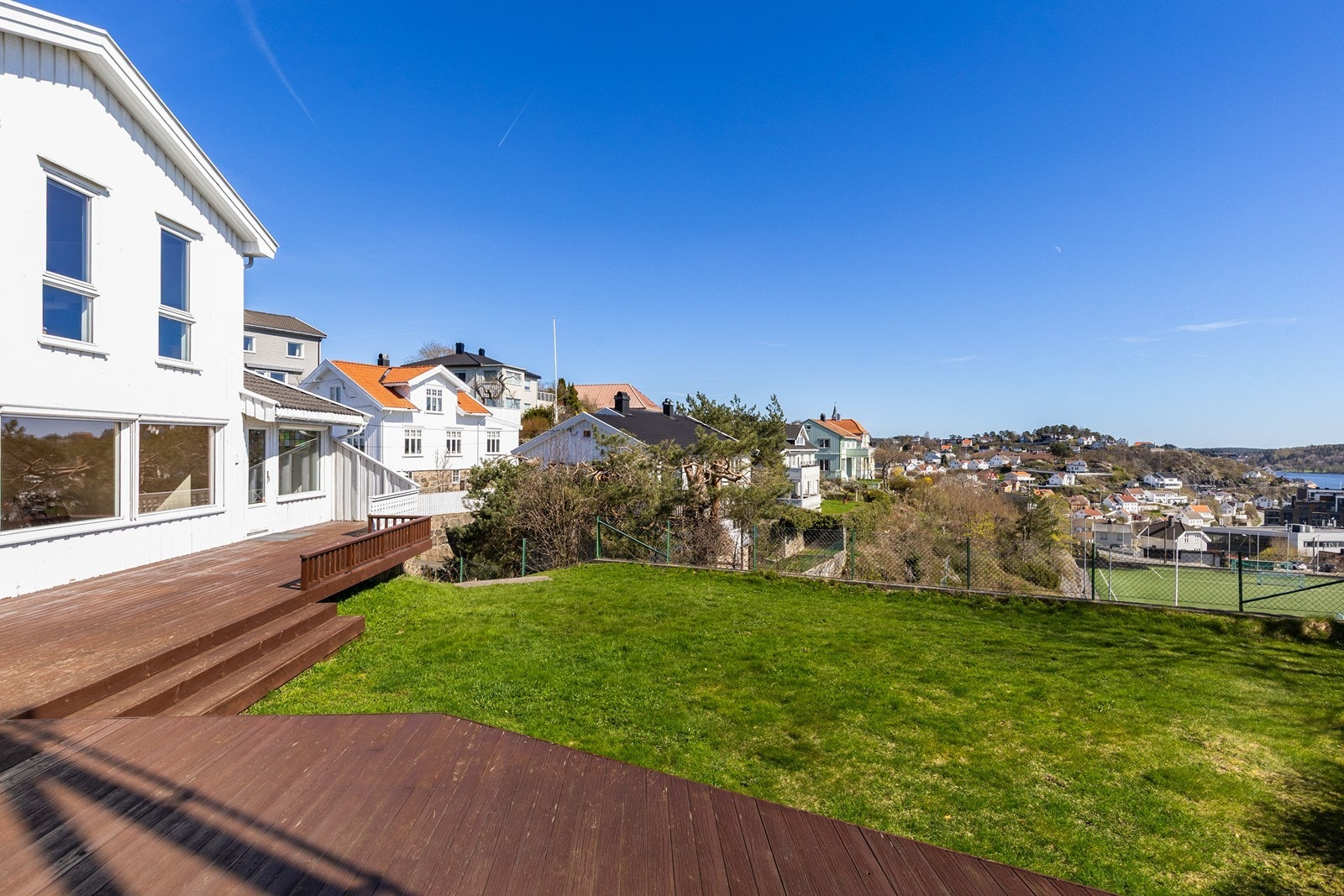 Romslig uteplass med stor terrasse og gressplen Galleribilde
