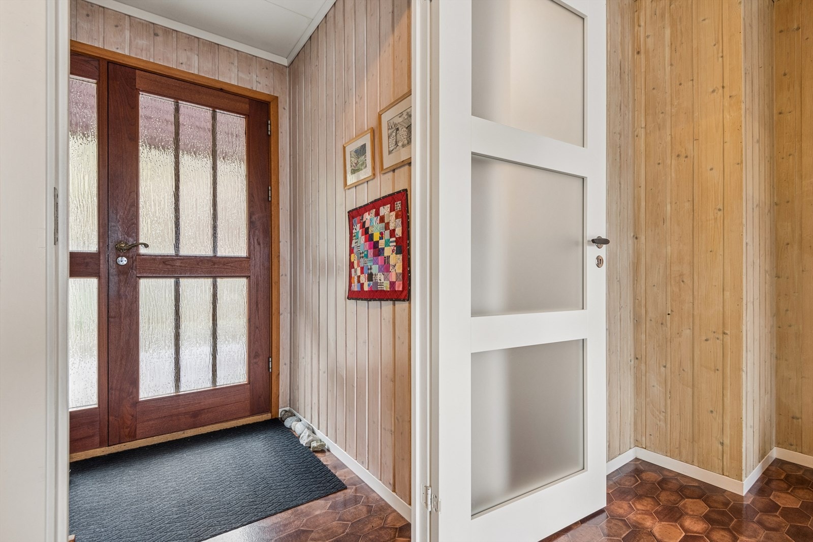 Vindfang med en solid ytterdør i teak som ønsker velkommen inn. Galleribilde