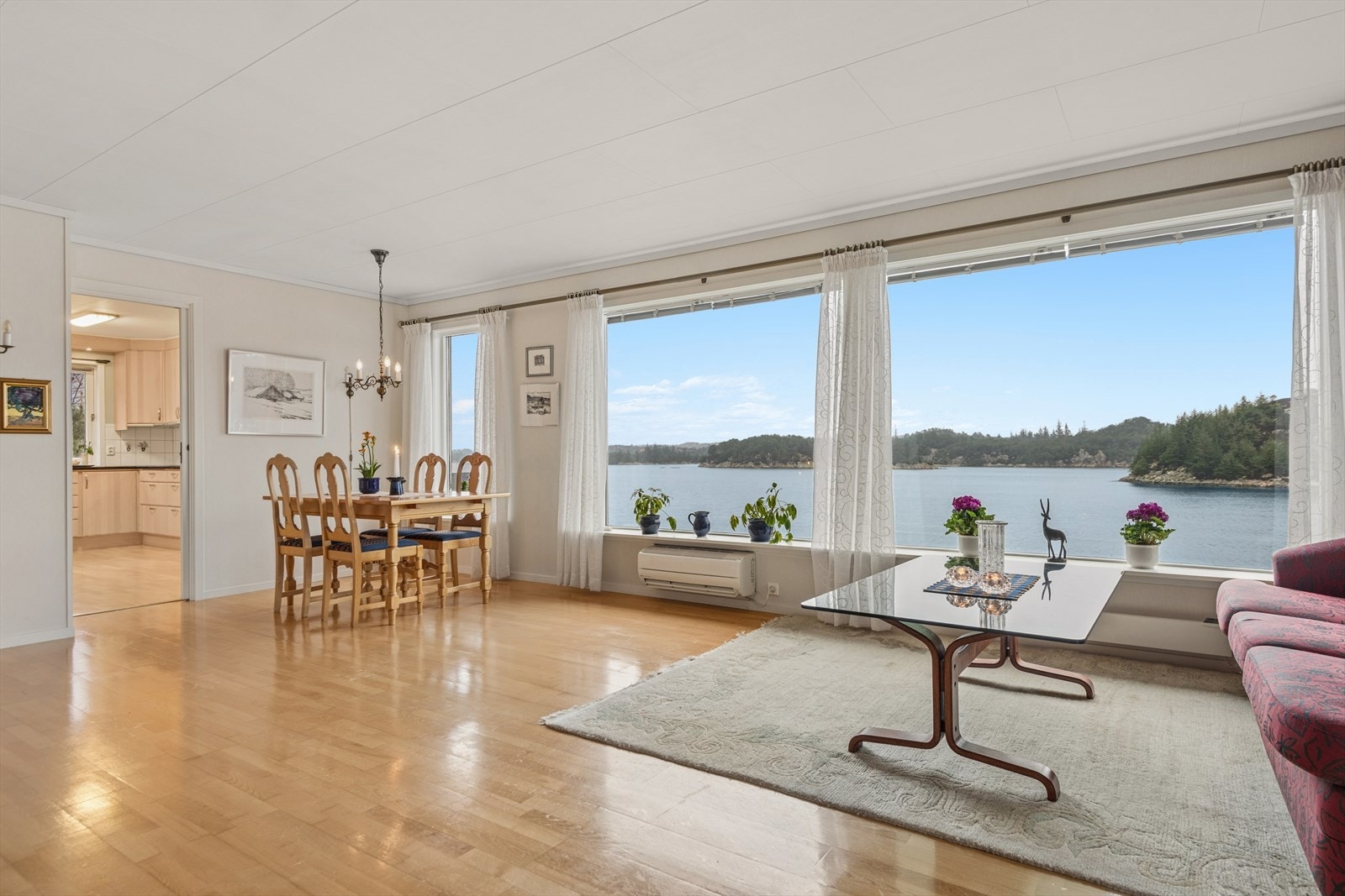 Den romslige stuen har store vindusflater som slipper inn rikelig med lys og rammer inn den flotte sjøutsikten. Galleribilde