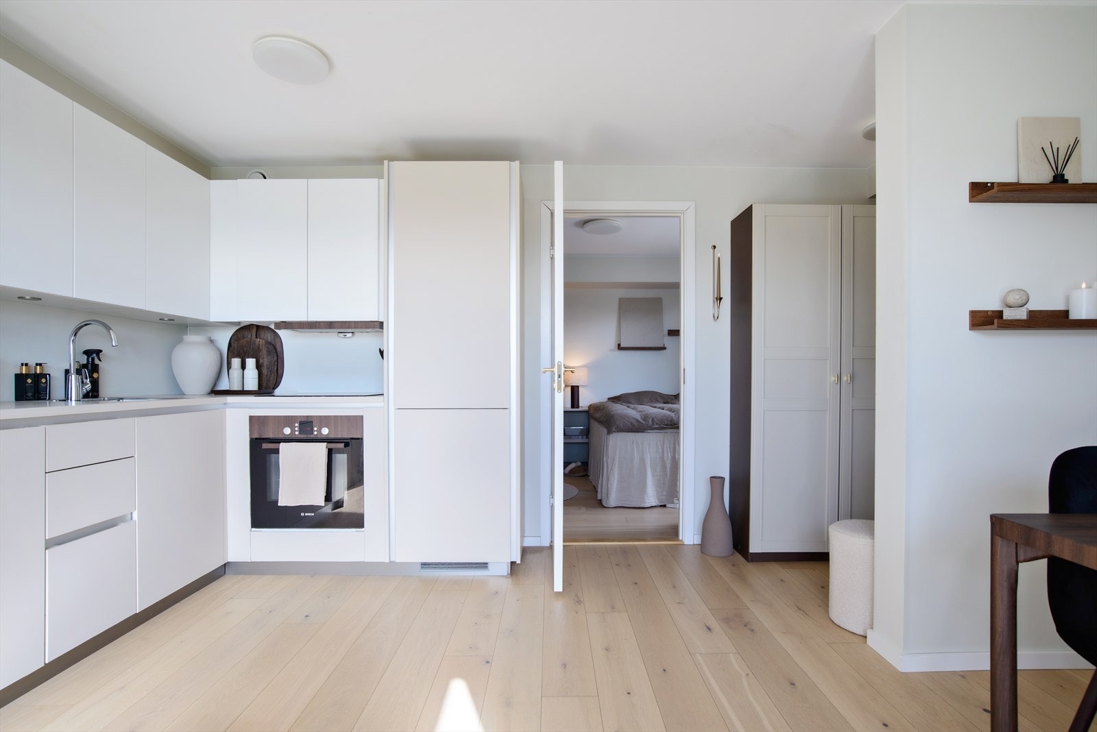 Stue og kjøkken er i åpen løsning med plass til både sofa og spiseplass, og gir en hyggelig og sosial sone. Kjøkkenet har slette lakkerte fronter og laminat benkeplate med nedfelt kum og platetopp med ventilator. Galleribilde