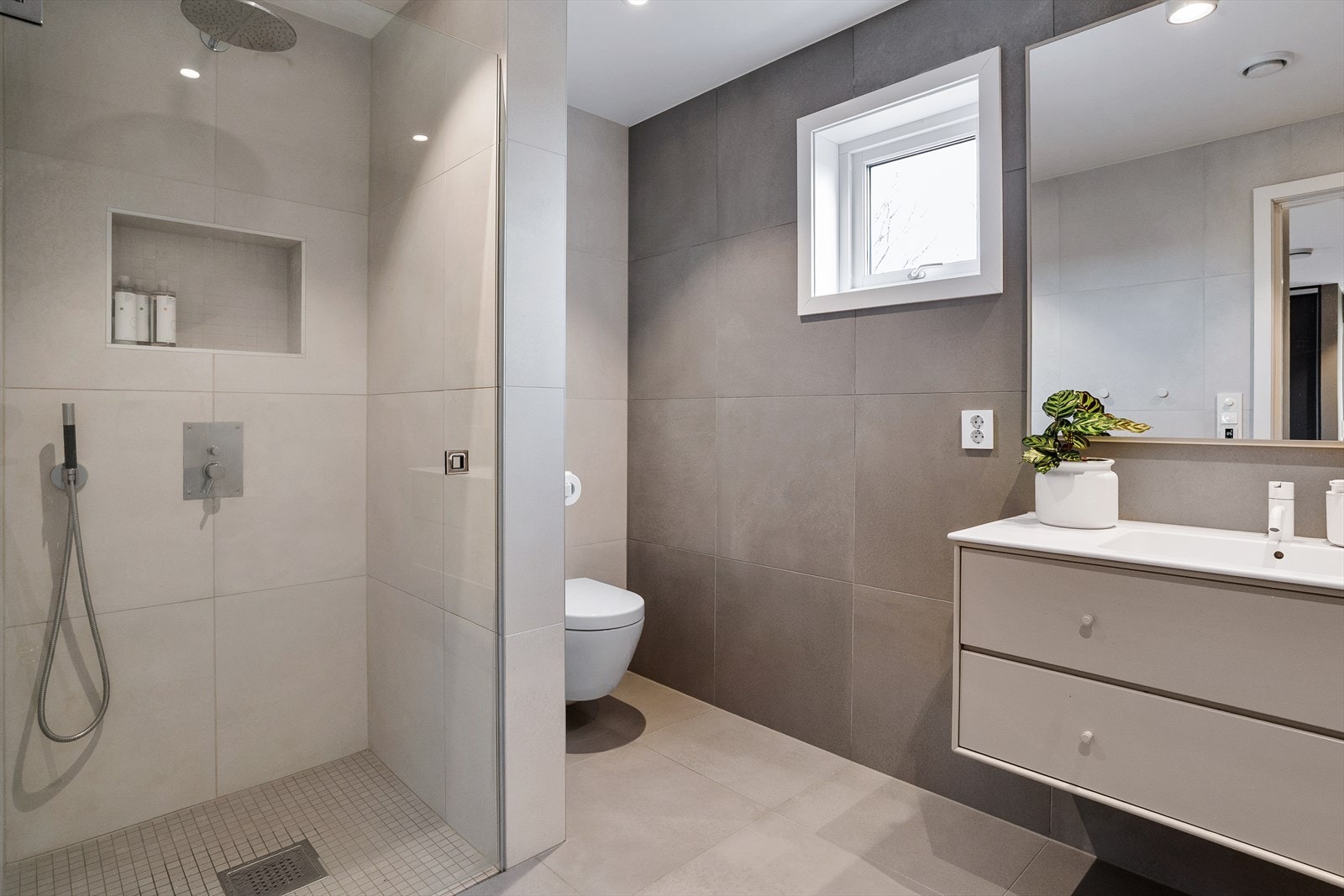 Badet som er tilknyttet hovedsoverommet har grå fliser og et tidløst uttrykk. Galleribilde