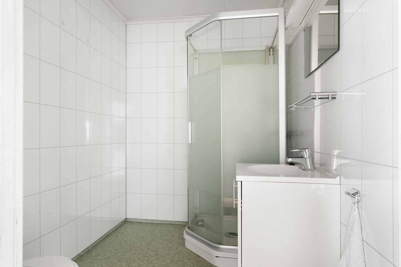 Lyst bad fra ca 2007 med baderomsplater på veggene, belegg på gulvet og prefabrikkerte malte plater i himlingen Galleribilde