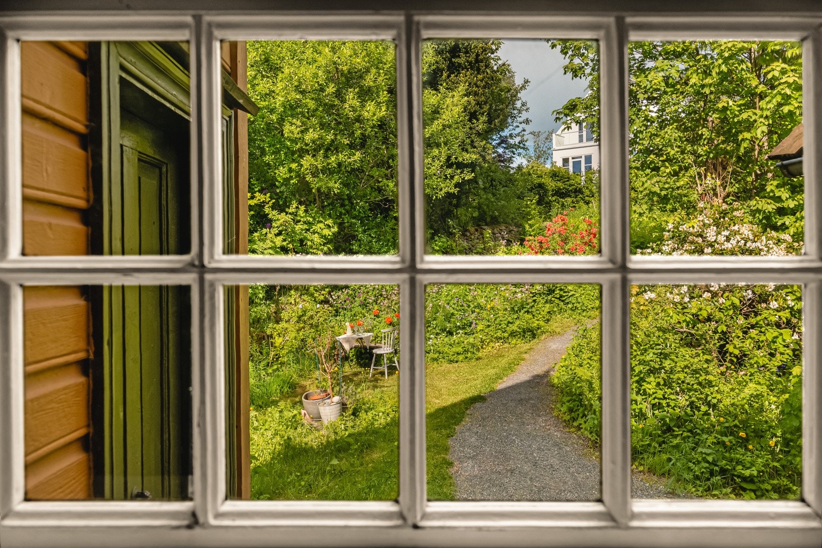 Utsikt fra et av vinduene mot den grønne og private hagen. Galleribilde