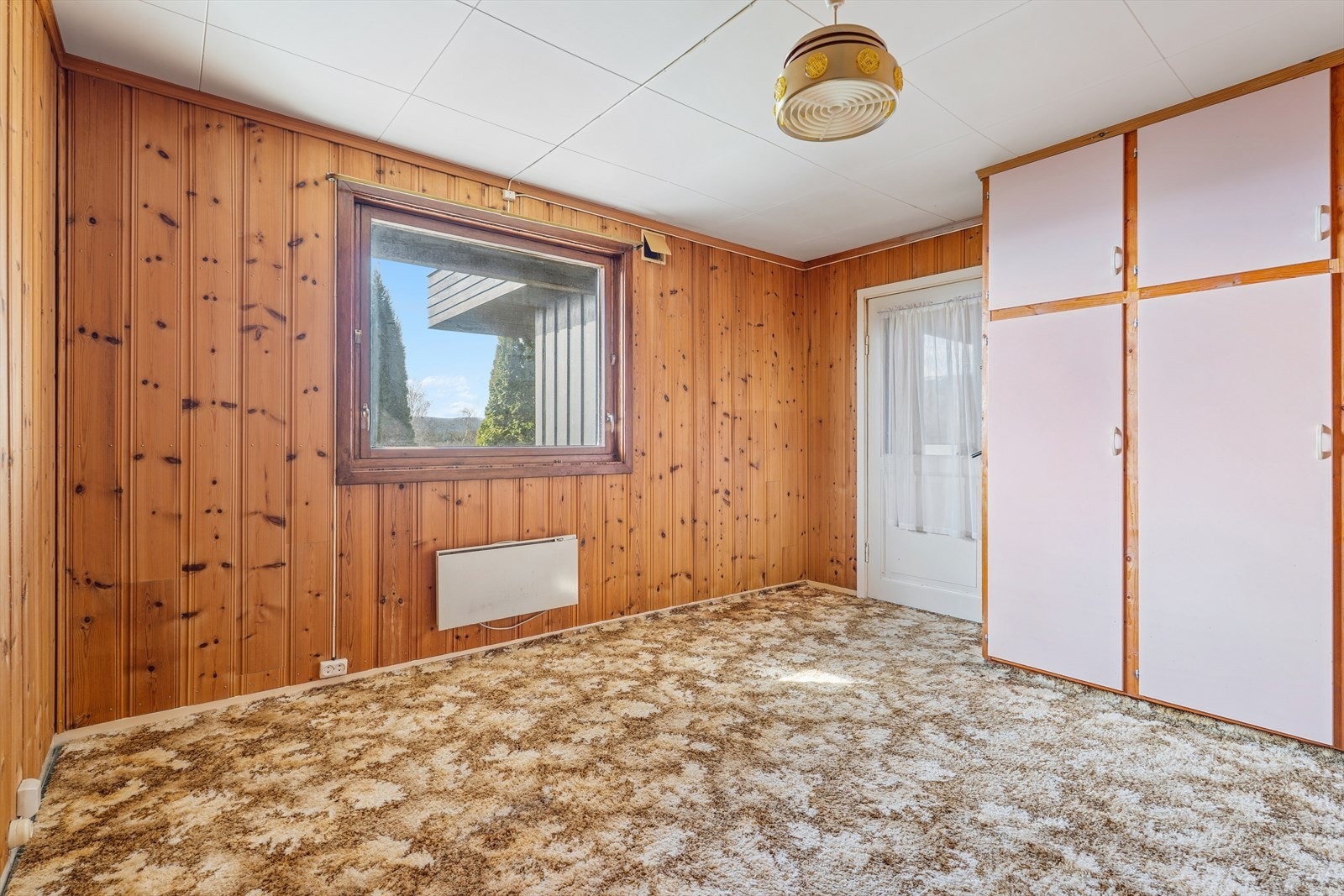 Boligen inneholder tre soverom. Dette rommet har vegger kledd med trepanel. Galleribilde