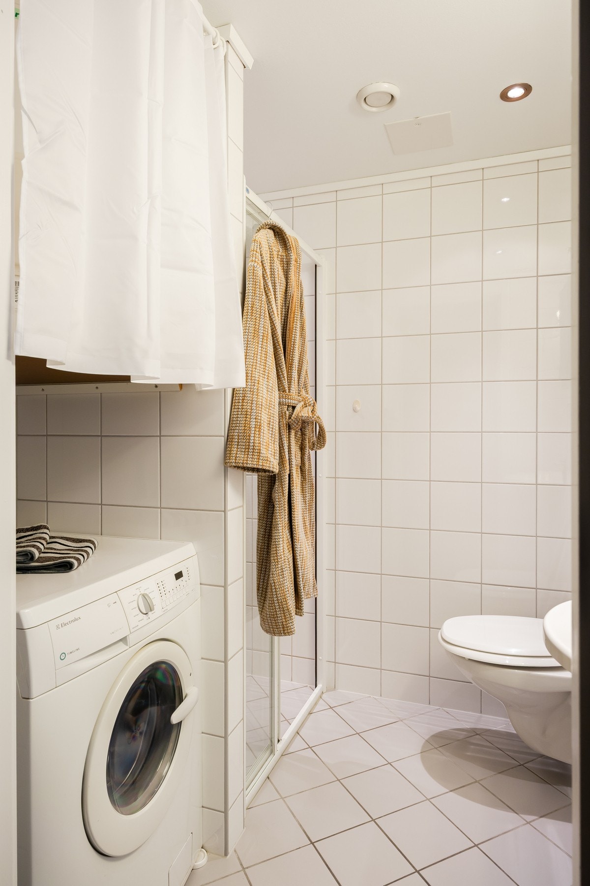 Her er baderomsinnredning, vegghengt toalett, dusjnisje og opplegg for vaskemaskin. Varmekabler i gulv og downlights i himling. Galleribilde