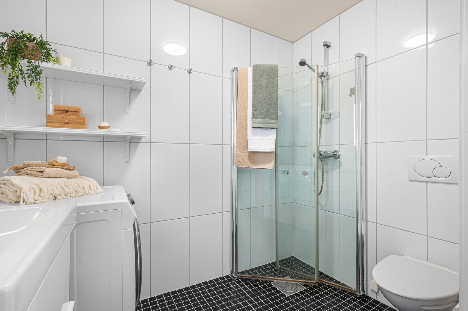 Badet er utstyrt med servantinnredning, speilskap med integrert belysning, dusjhjørne og vegghengt toalett. Galleribilde