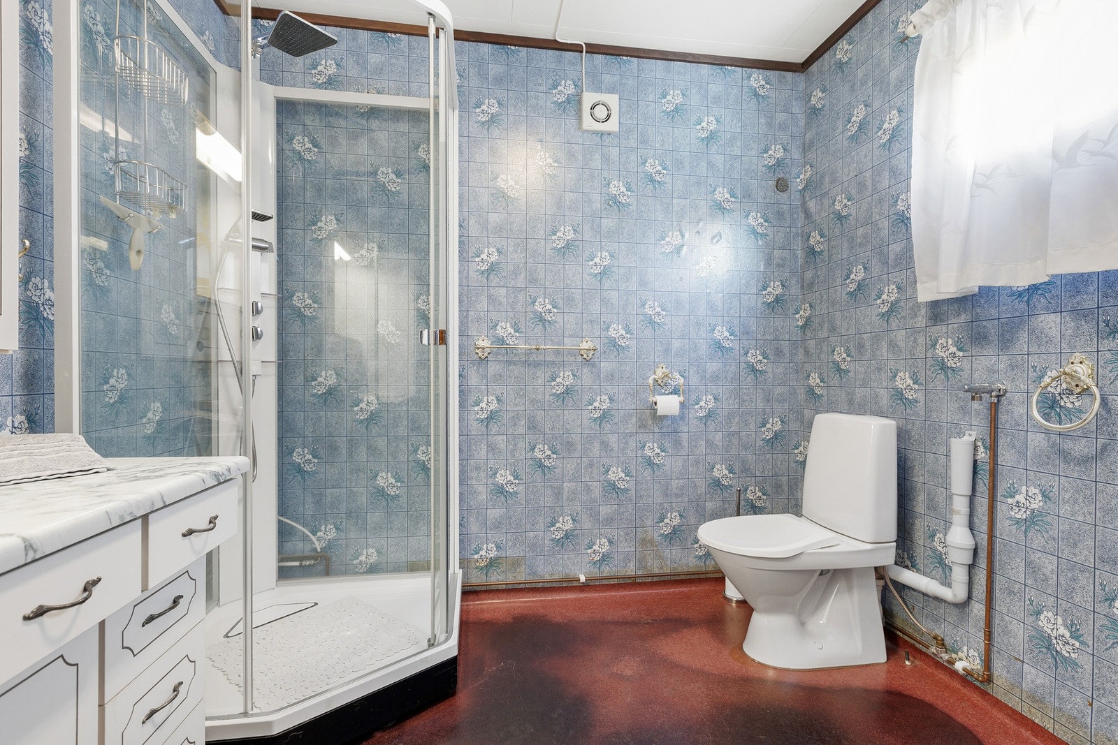 Badet er utstyrt med dusjkabinett og gulvmontert toalett. Galleribilde