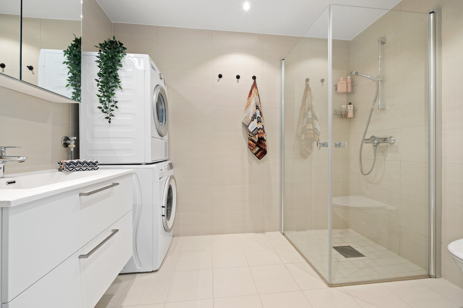 Badet er flislagt med varmekabler i gulv og downlights i himling Galleribilde