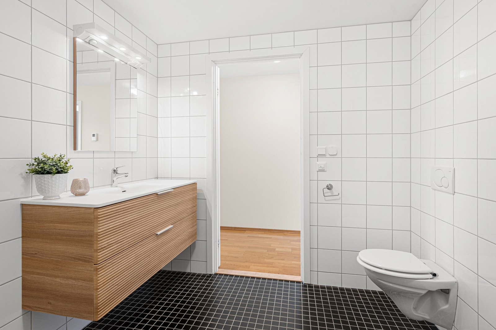 Flott og tidløst helfliset bad med varme i gulv. Det er opplegg for vaskemaskin. Galleribilde