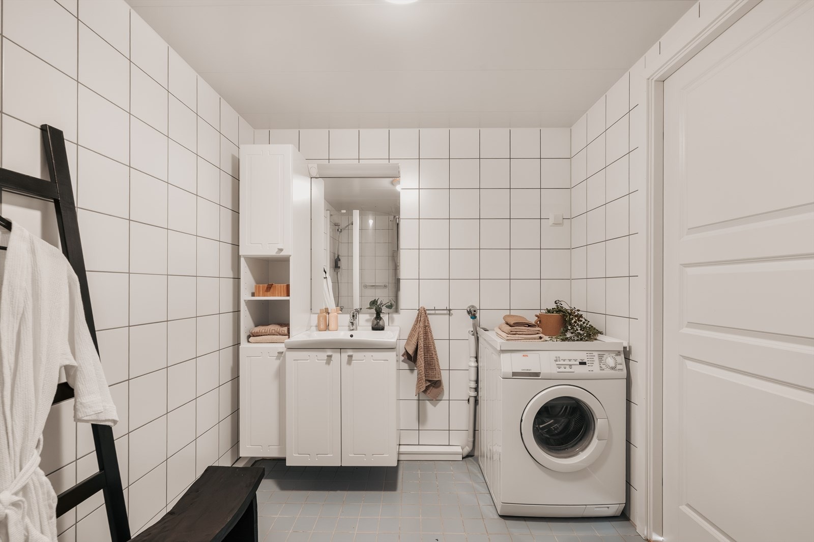 Badet er utstyrt med dusjkabinett, vegghengt toalett, servantinnredning og har opplegg for vaskemaskin. Galleribilde