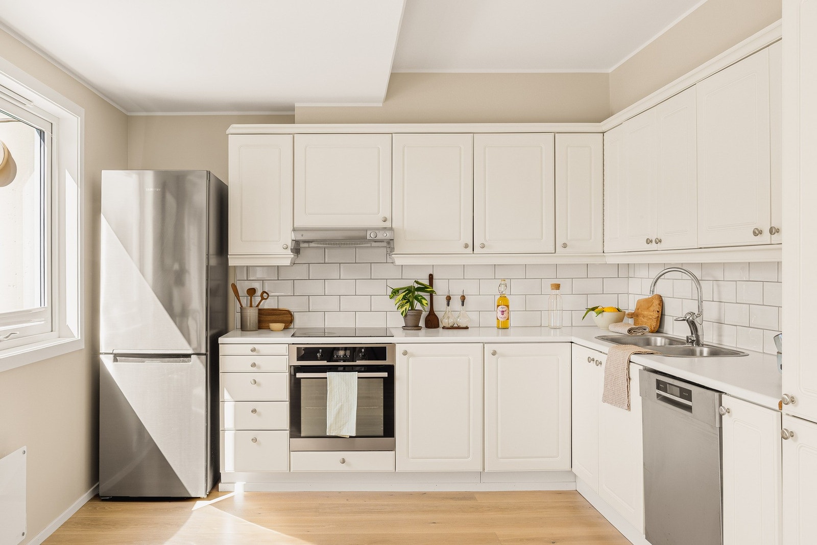 Kjøkkeninnredning med profilerte fronter og laminat
benkeplate med nedfelt vask av stål. Galleribilde